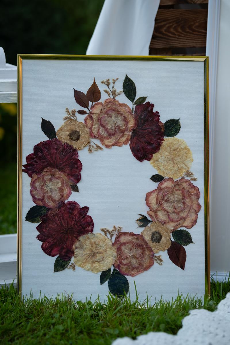 Elegancki obraz z suszonych kwiatów w złotej ramce, kompozycja w kształcie wieńca. Pamiątkowy obraz Karokwiaty.