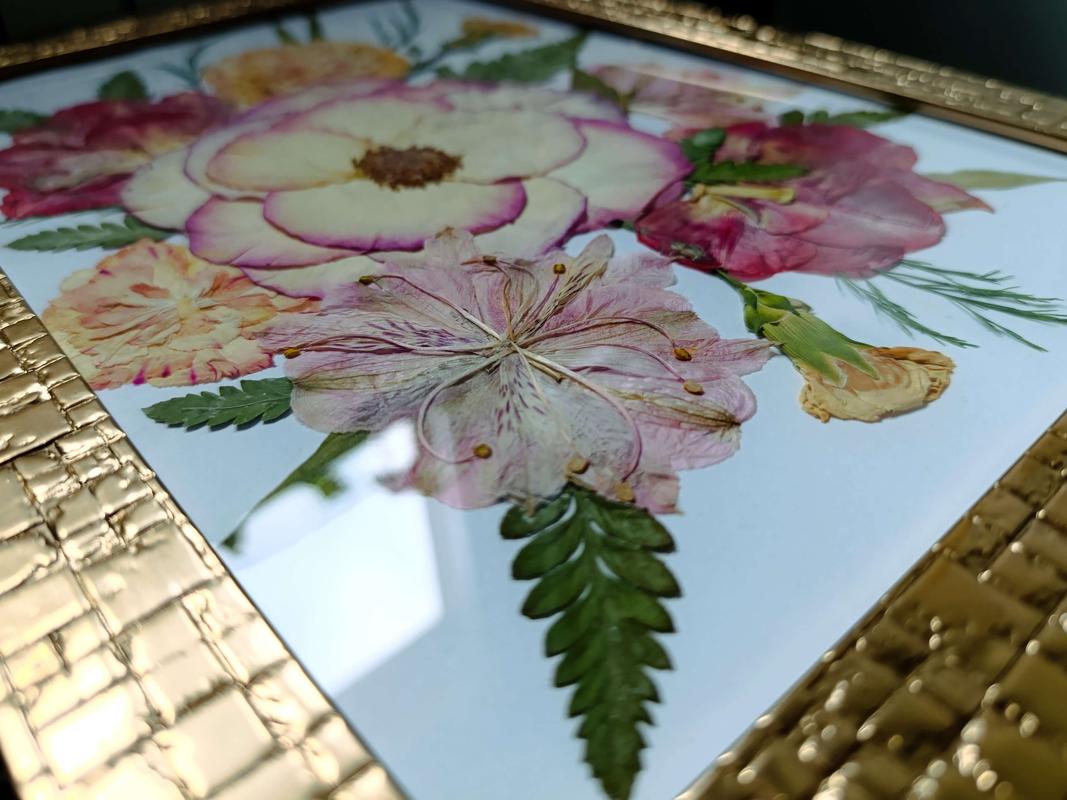 Elegancki obraz z suszonych kwiatów w złotej ramce, kompozycja w odcieniach kremu, różu i zieleni. Pamiątkowy obraz Karokwiaty.